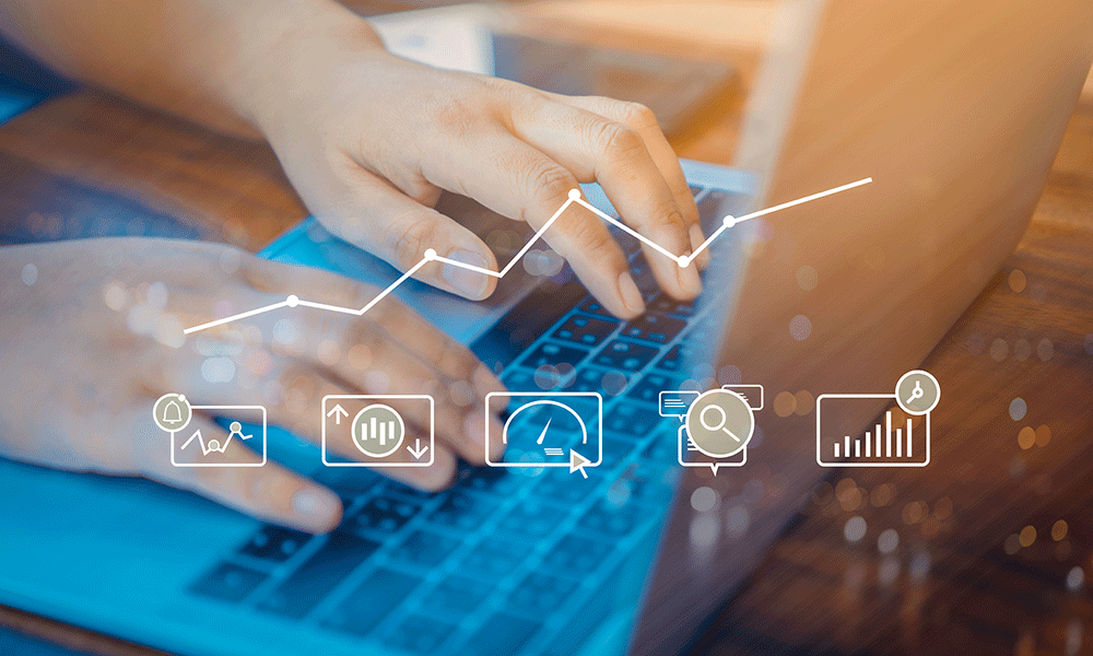 Hands typing on a laptop with overlay graphics of data analysis icons and a rising line graph.