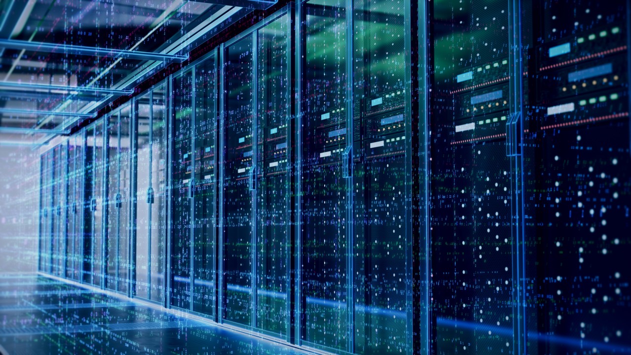 A row of illuminated data servers in a server room, with blue and green lights indicating electronic activity and processing.