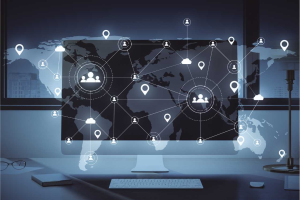 A computer monitor displays a world map with network connection icons, indicating global digital connectivity and data sharing.